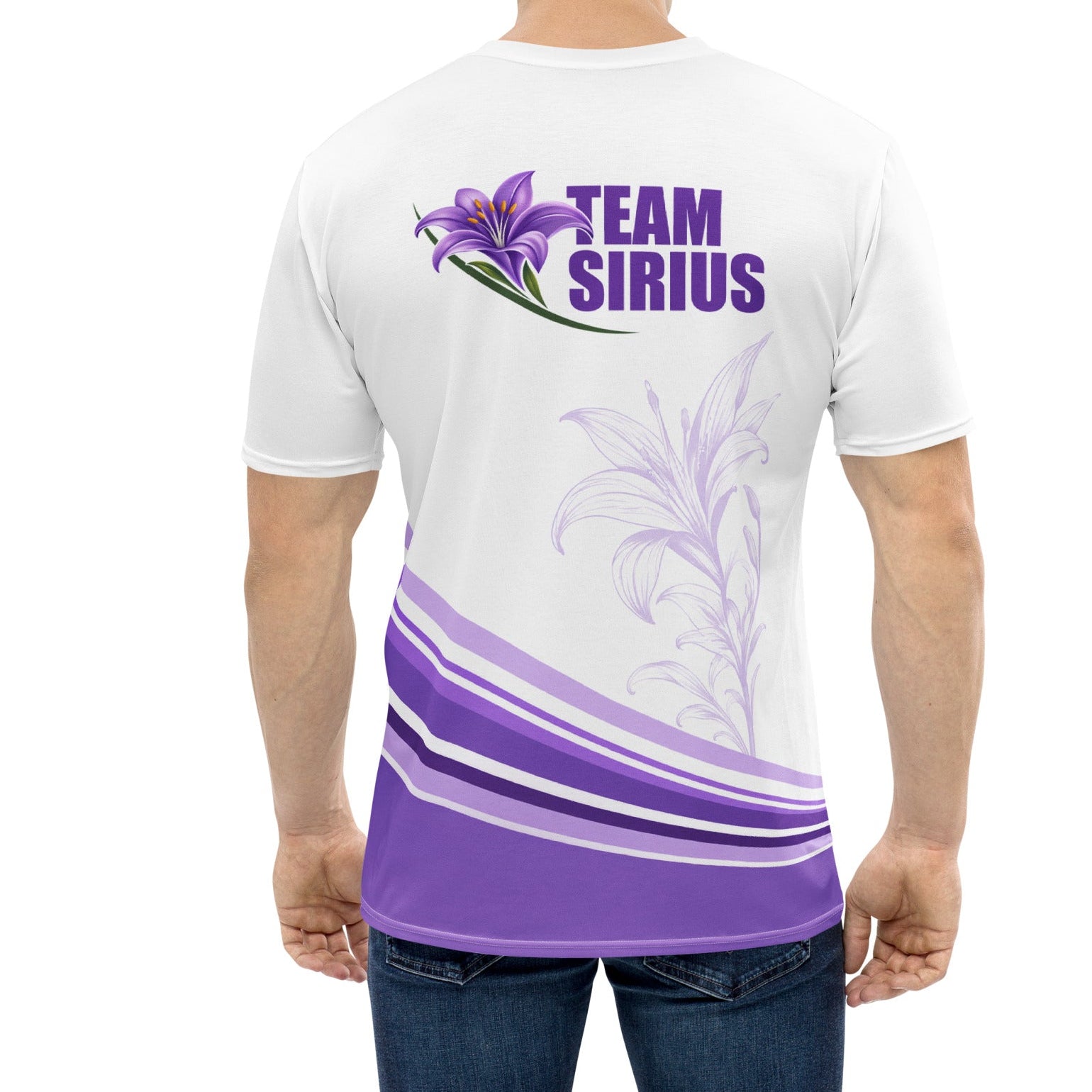 A man viewed from the back wearing a white short-sleeve t-shirt with a purple graphic on the back. The graphic features a purple lily flower, the text 'TEAM SIRIUS' in purple, and purple and white wavy stripes near the hem.